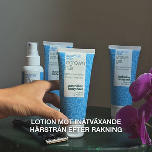 Video: After Shave spray, Pre-shave Scrub, Ingrown Hair lotion och Shave Gel står på ett bord bredvid en rakhyvel och en orkidé, med texten ”lotion mot inåtväxande hårstrån efter rakning”. Salicylsyra Aftershave Lotion från Australian Bodycare.